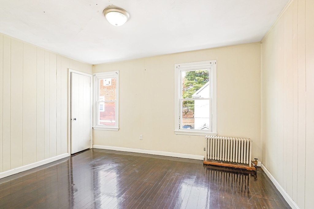 18 Sycamore Street Springfield, MA 01109 - Photo 16 of 22 an empty room with wooden floor and windows