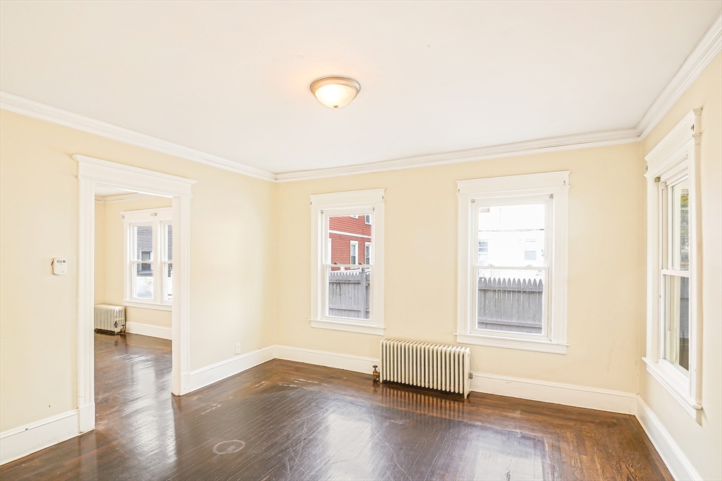 18 Sycamore Street Springfield, MA 01109 - Photo 19 of 22 an empty room with wooden floor and windows