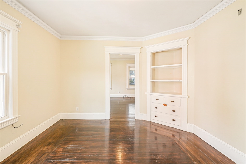 18 Sycamore Street Springfield, MA 01109 - Photo 8 of 22 an empty room with cabinet and wooden floor