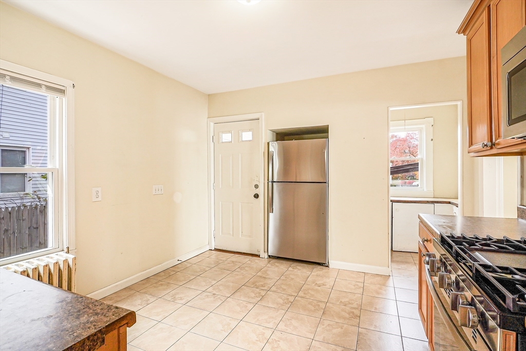 18 Sycamore Street Springfield, MA 01109 - Photo 9 of 22 a kitchen with granite countertop a refrigerator and a stove