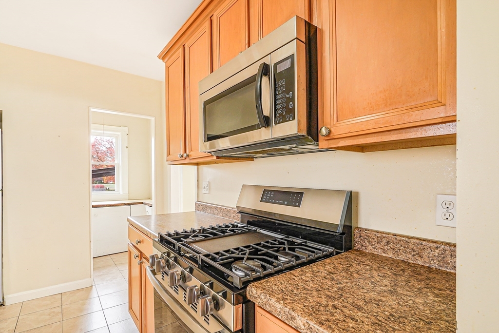 18 Sycamore Street Springfield, MA 01109 - Photo 10 of 22 a kitchen with stainless steel appliances granite countertop a stove a sink and a microwave