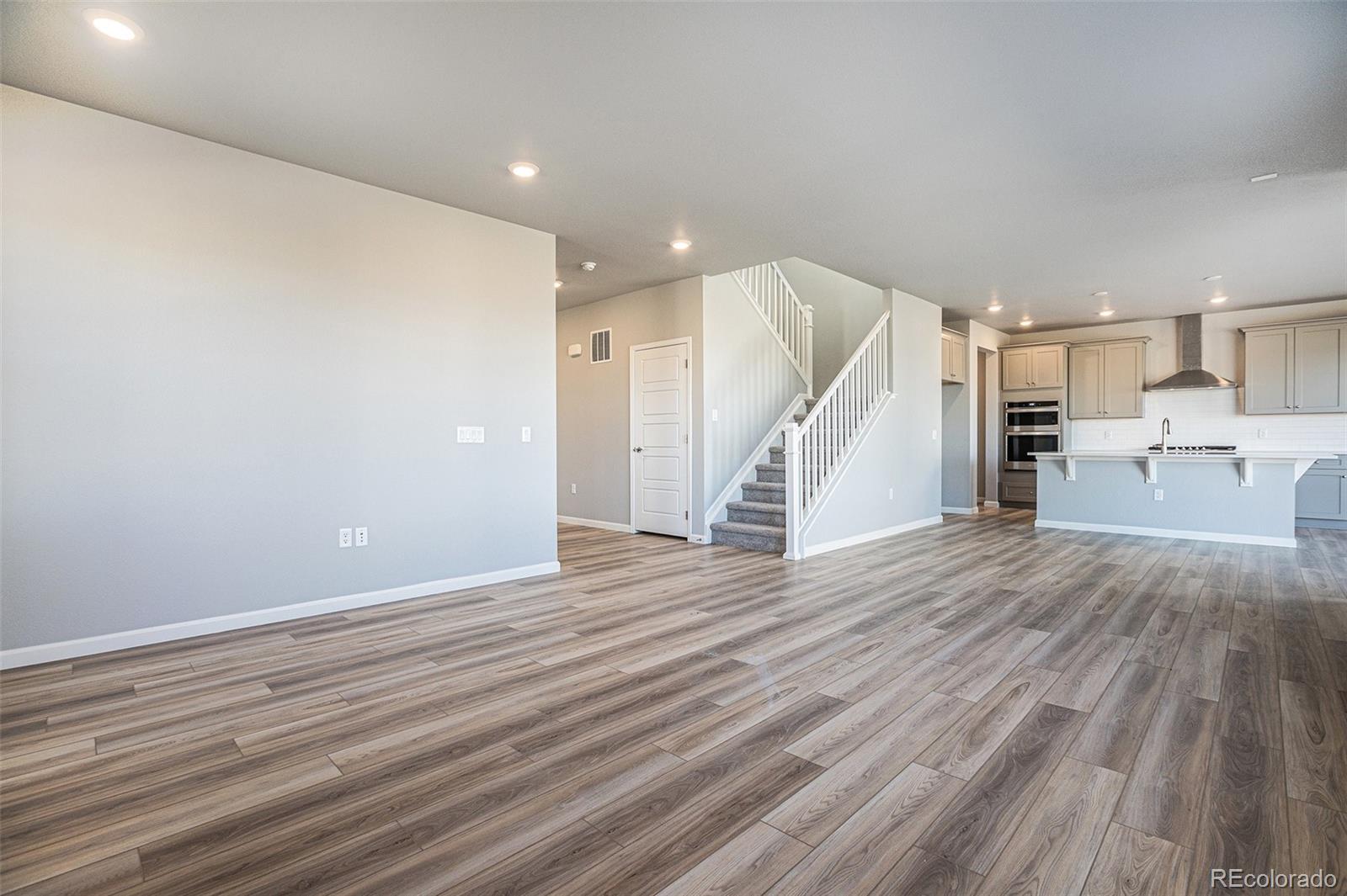 15965 Stringhalt Way Parker, CO 80134 - Photo 12 of 33 a view of a kitchen with wooden floor and staircase