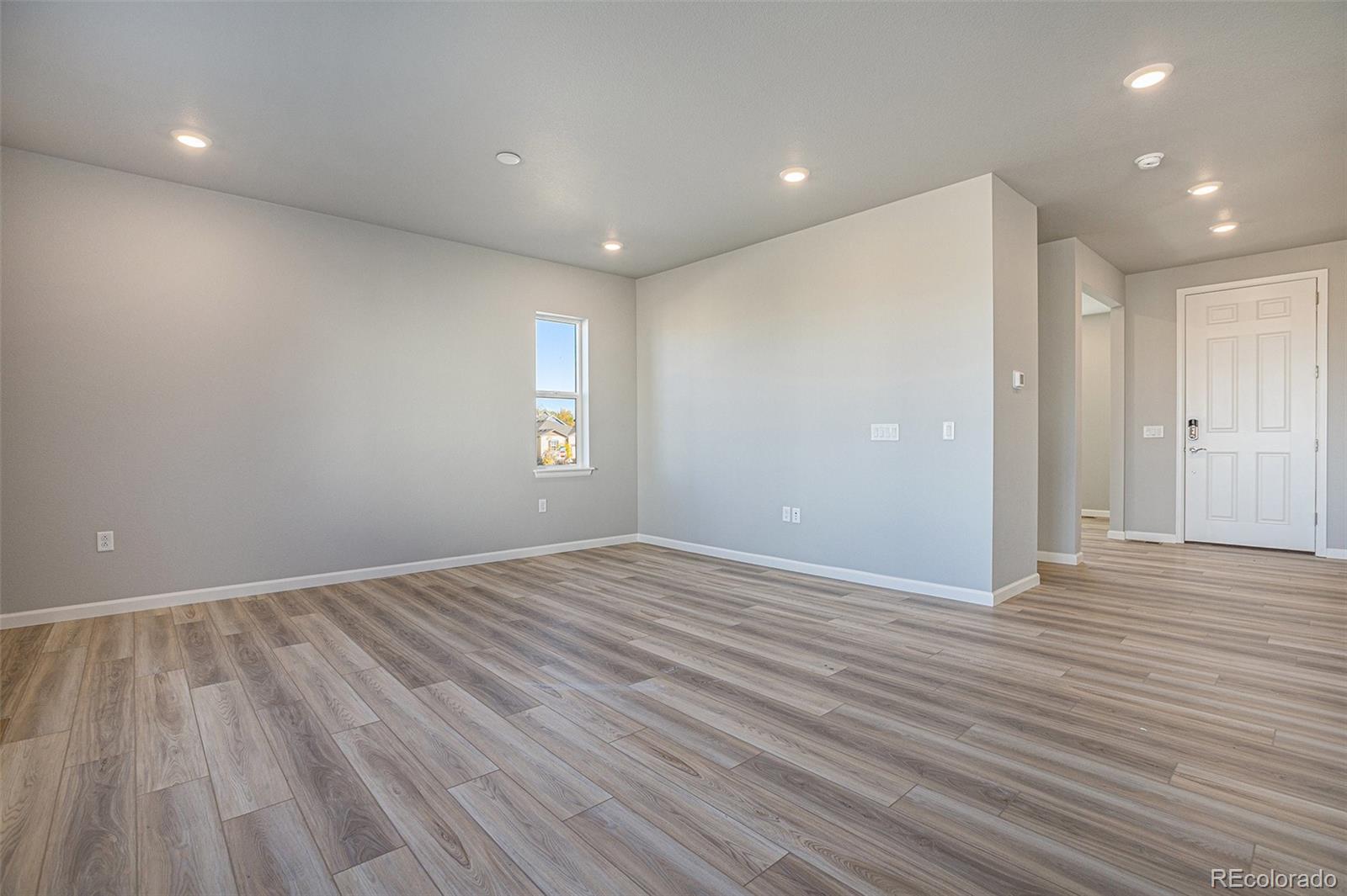 15965 Stringhalt Way Parker, CO 80134 - Photo 14 of 33 an empty room with wooden floor and windows