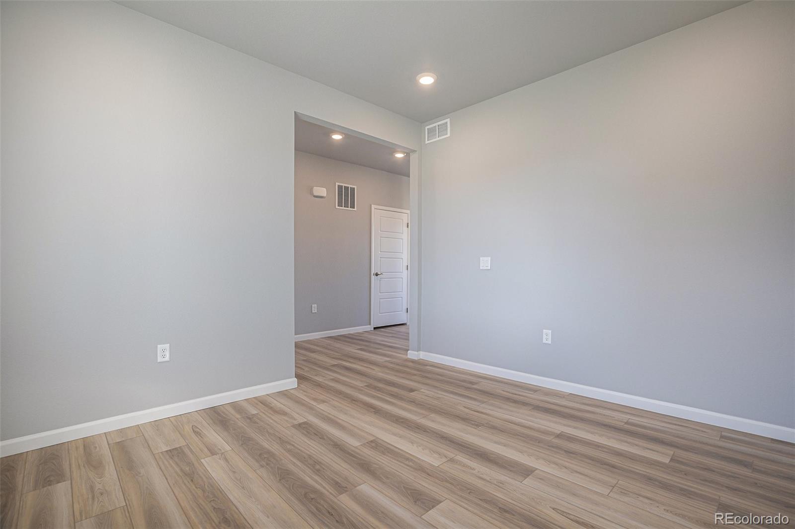15965 Stringhalt Way Parker, CO 80134 - Photo 15 of 33 a view of an empty room with wooden floor