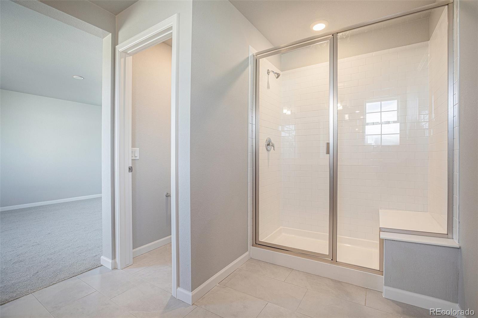 15965 Stringhalt Way Parker, CO 80134 - Photo 25 of 33 a bathroom with a shower and a glass door
