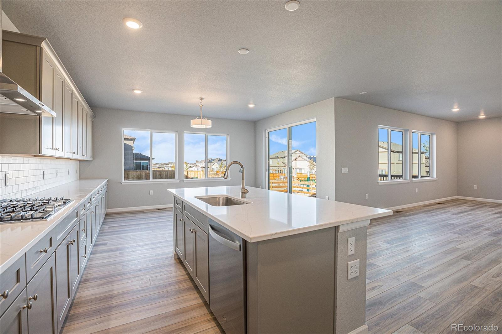 15965 Stringhalt Way Parker, CO 80134 - Photo 6 of 33 a kitchen with stainless steel appliances granite countertop a sink stove and wooden floor