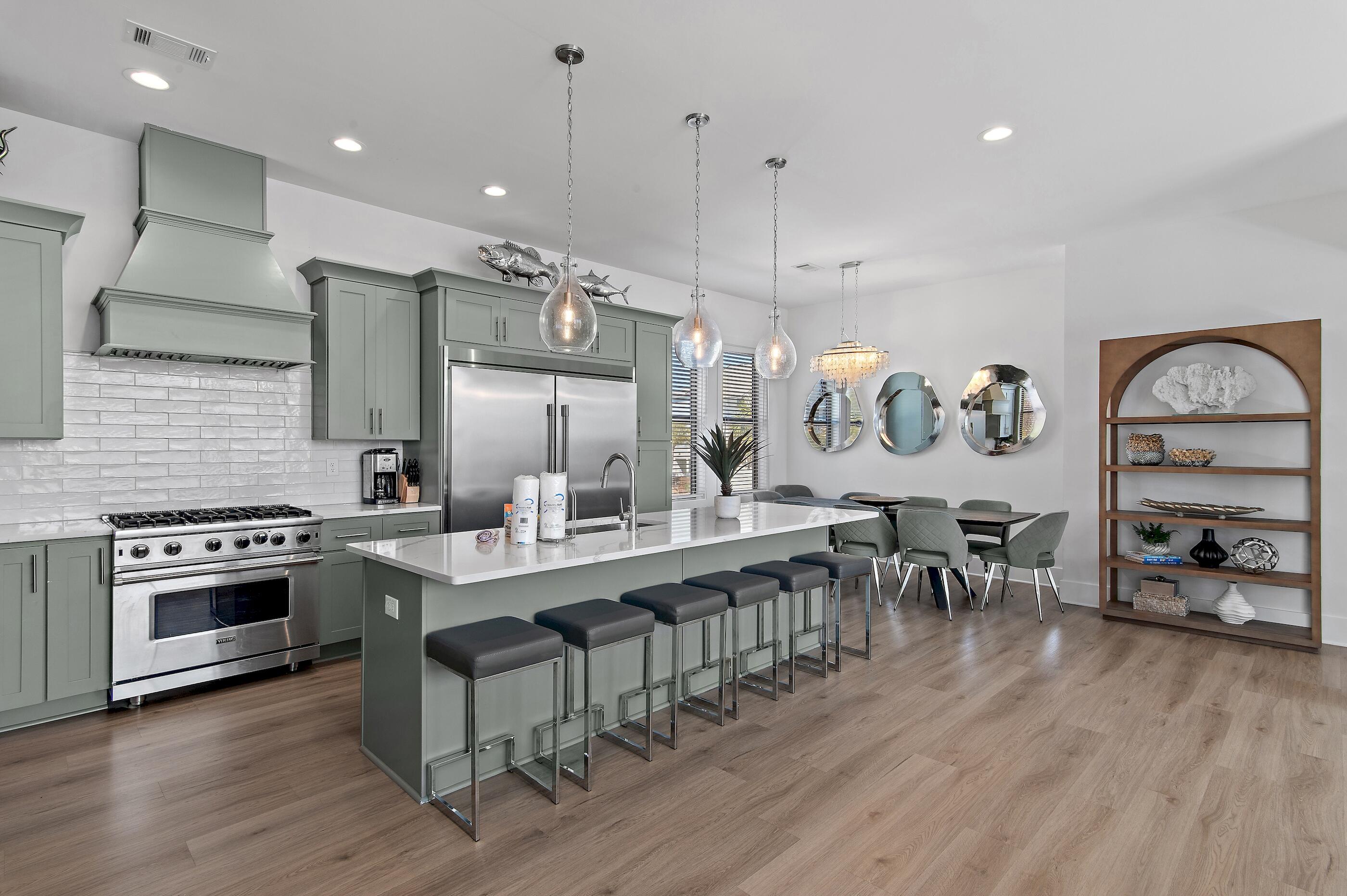 217 Snowdrift Road Miramar Beach, FL 32550 - Photo 12 of 66 a kitchen with stainless steel appliances granite countertop a stove a sink dishwasher a dining table and chairs with wooden floor