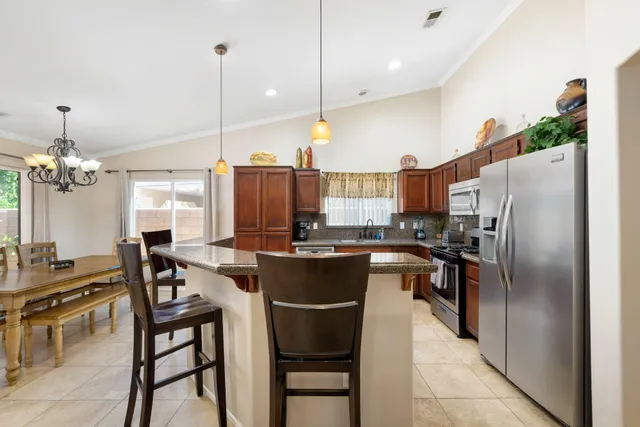 a kitchen with a table chairs refrigerator and microwave