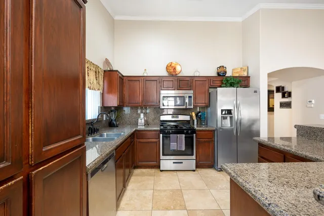 a kitchen with stainless steel appliances granite countertop a sink and stove