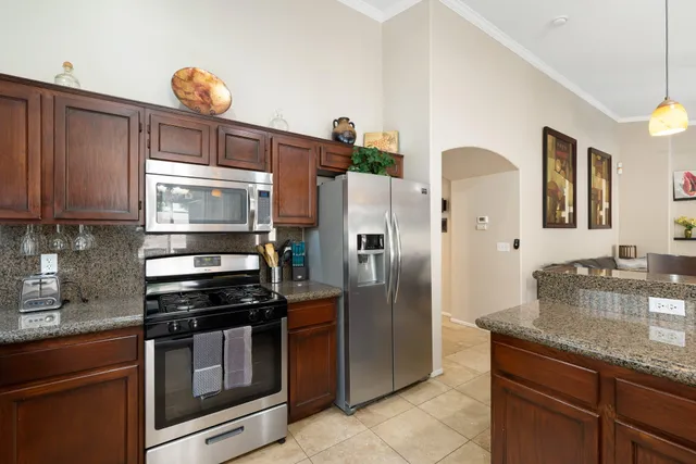 a kitchen with stainless steel appliances granite countertop a sink and a refrigerator