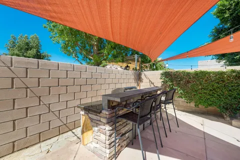 a backyard of a house with table and chairs