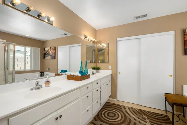 a spacious bathroom with a sink double vanity and a mirror