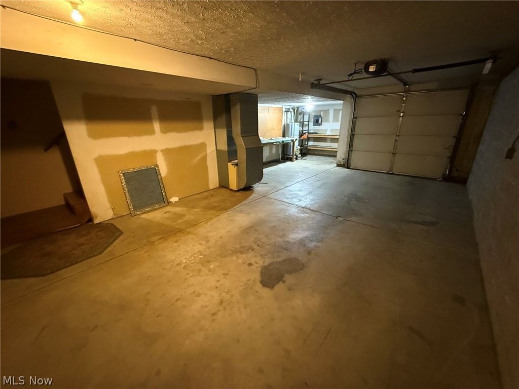 604 Harger Street Dover, OH 44622 - Photo 19 of 25 Garage with heating unit, water heater, and a garage door opener