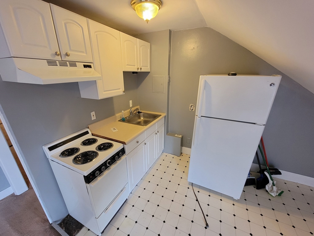 a kitchen with sink a refrigerator and a stove top oven