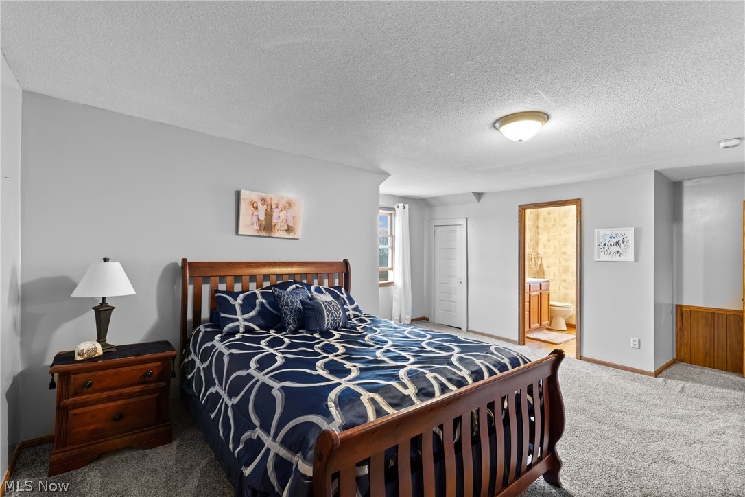 64508 Slade Road Cambridge, OH 43725 - Photo 24 of 50 2nd floor primary bedroom featuring a closet, a textured ceiling, and connected bathroom