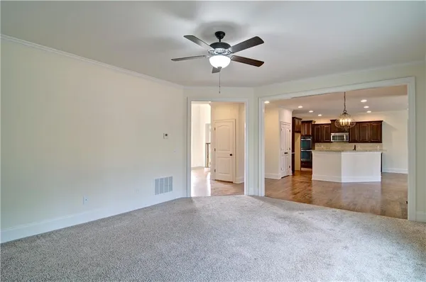an empty room with a window and a fan