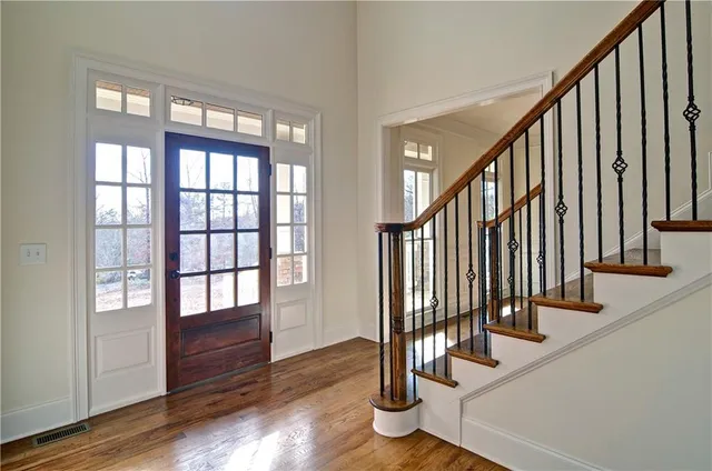 a view of a hallway with wooden floor and stairs