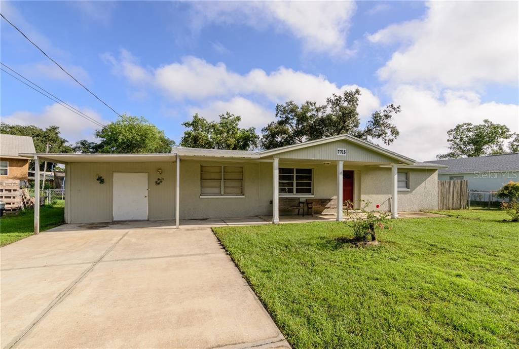 a front view of house with yard and trees in the background