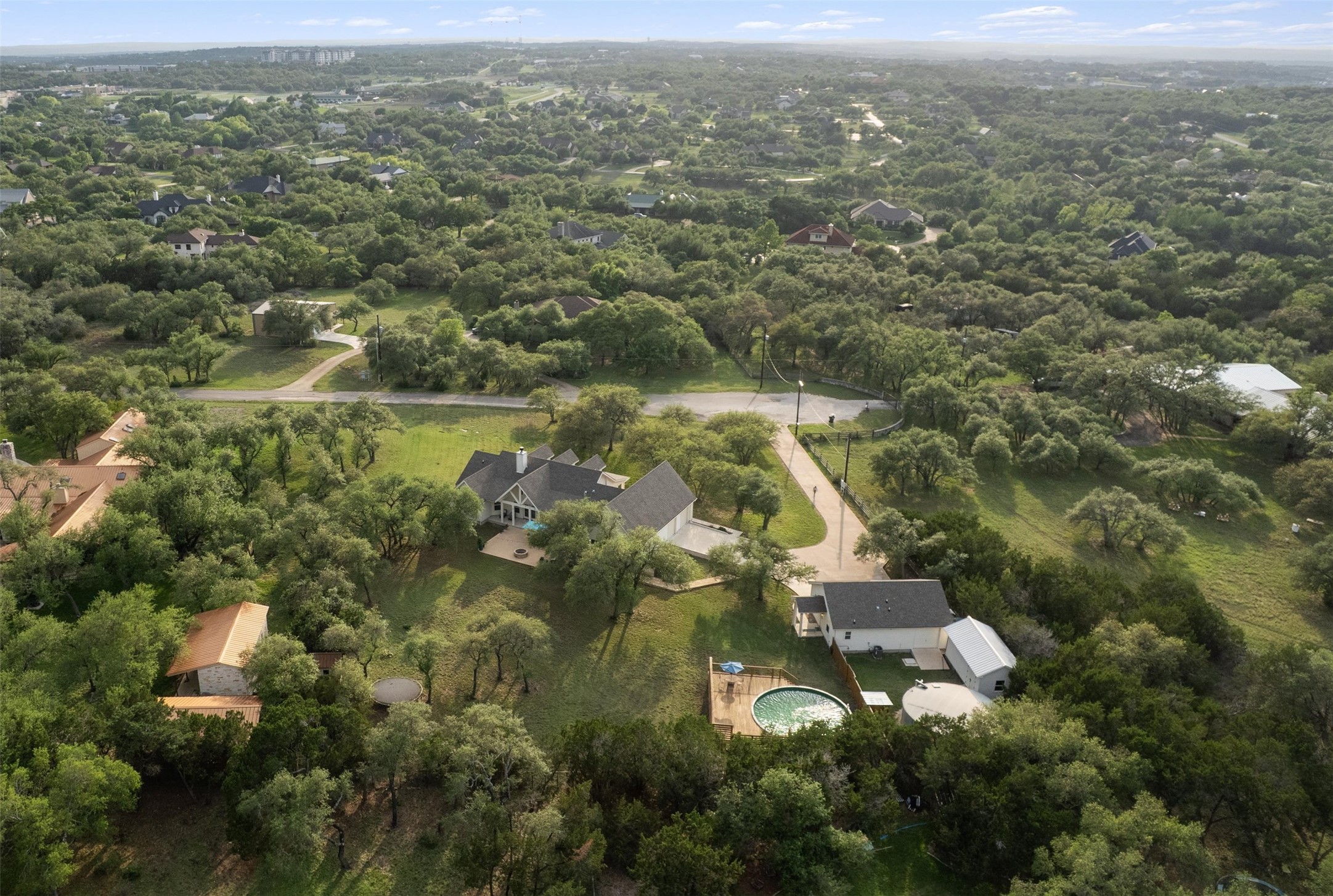 13105 Rooster Springs Road Austin, TX 78737 - Photo 35 of 38 The property features a residence with an expansive yard, surrounded by mature trees, and includes an above-ground pool with a surrounding deck