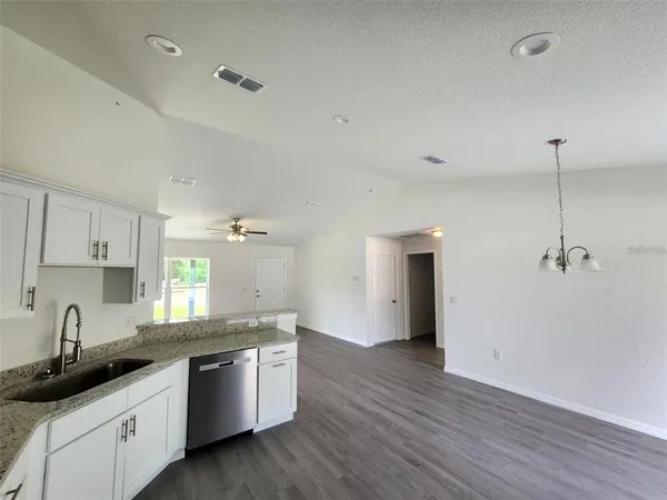 a kitchen with a sink cabinets and wooden floor