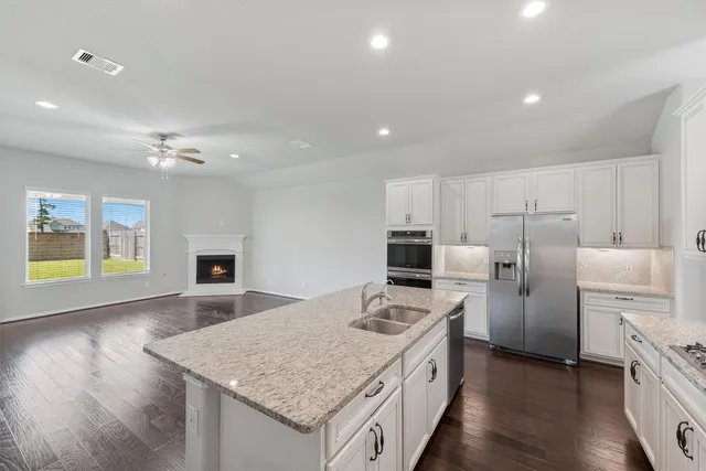 a kitchen with refrigerator cabinets and wooden floor