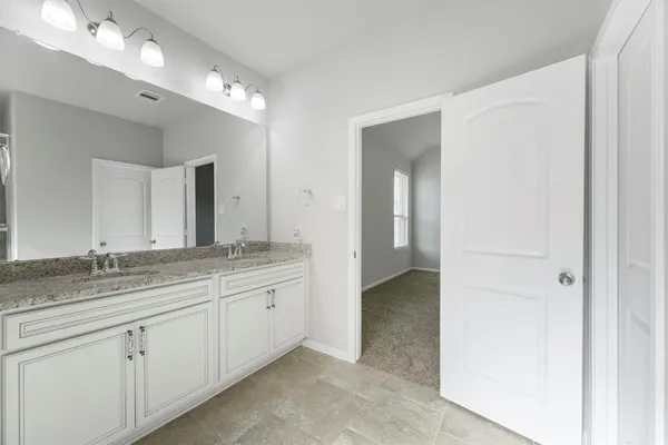a spacious bathroom with a granite countertop sink a mirror and a shower