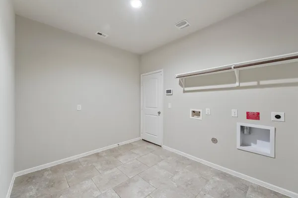 an empty room with a chandelier fan and windows