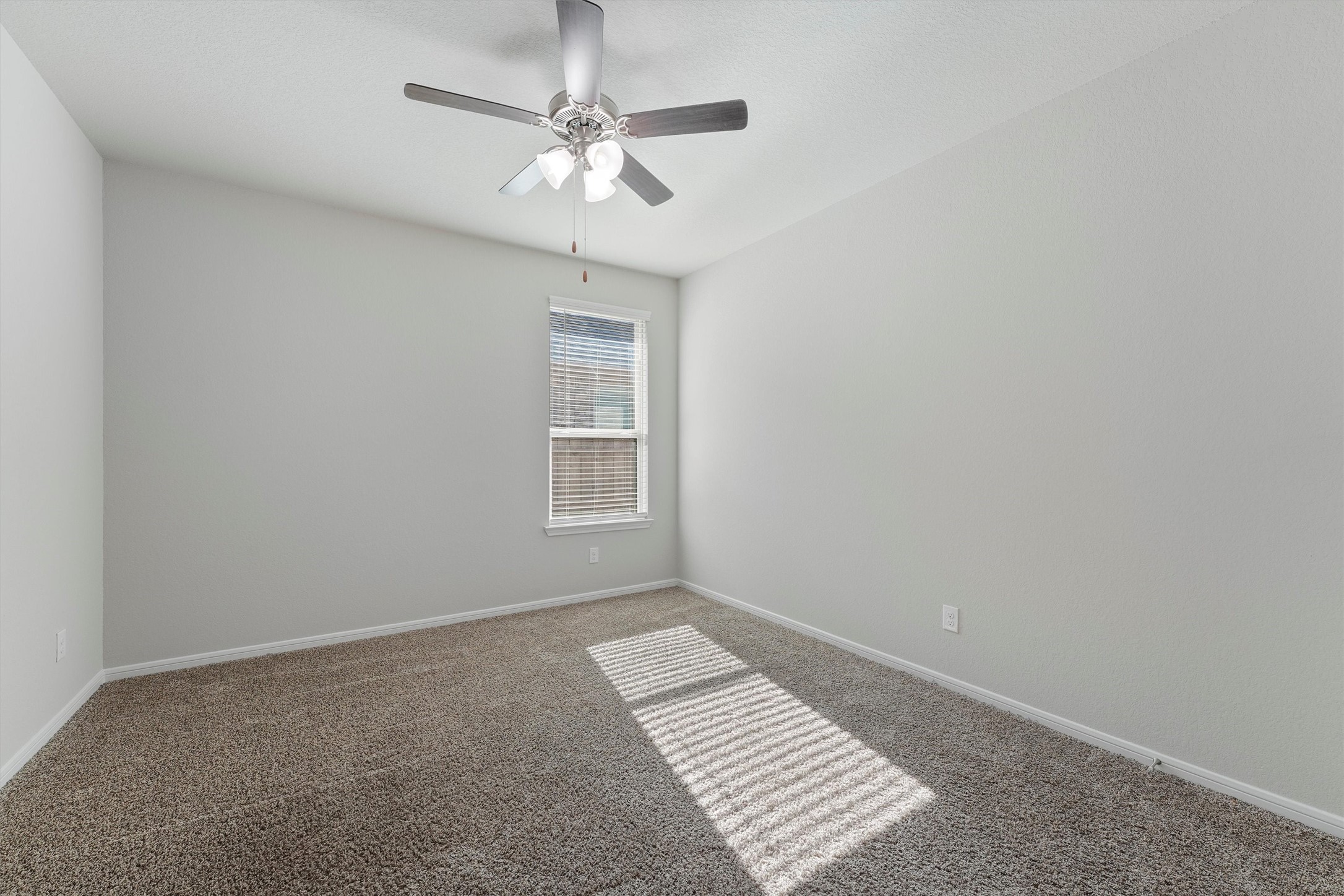 12043 Talmadge Reach Drive Humble, TX 77346 - Photo 21 of 33 an empty room with a chandelier fan and windows