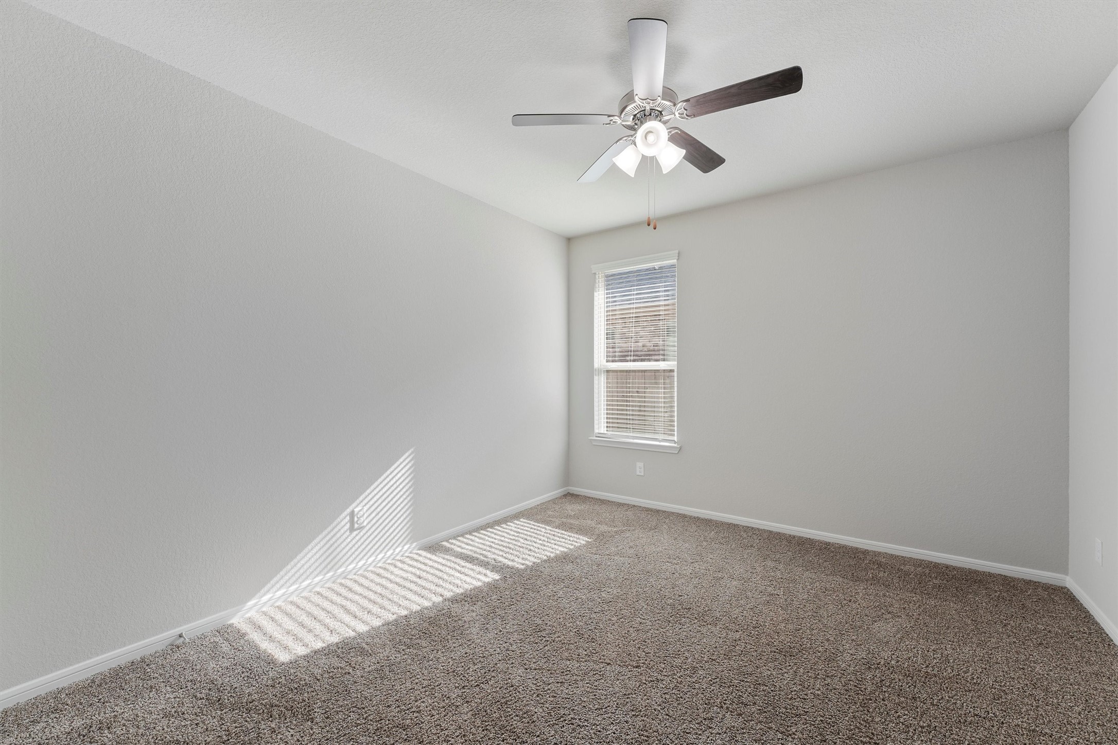 12043 Talmadge Reach Drive Humble, TX 77346 - Photo 22 of 33 an empty room with a chandelier fan and windows