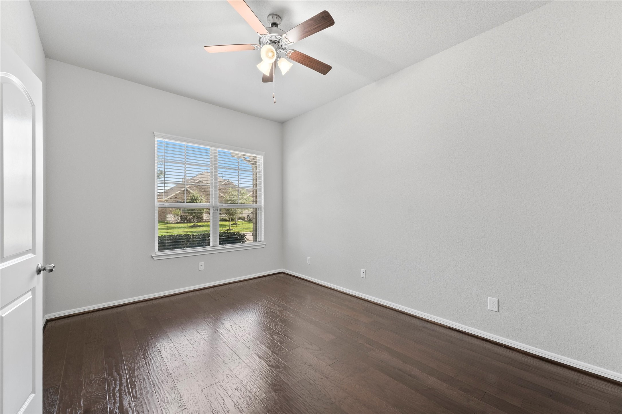 12043 Talmadge Reach Drive Humble, TX 77346 - Photo 4 of 33 an empty room with wooden floor chandelier fan and windows