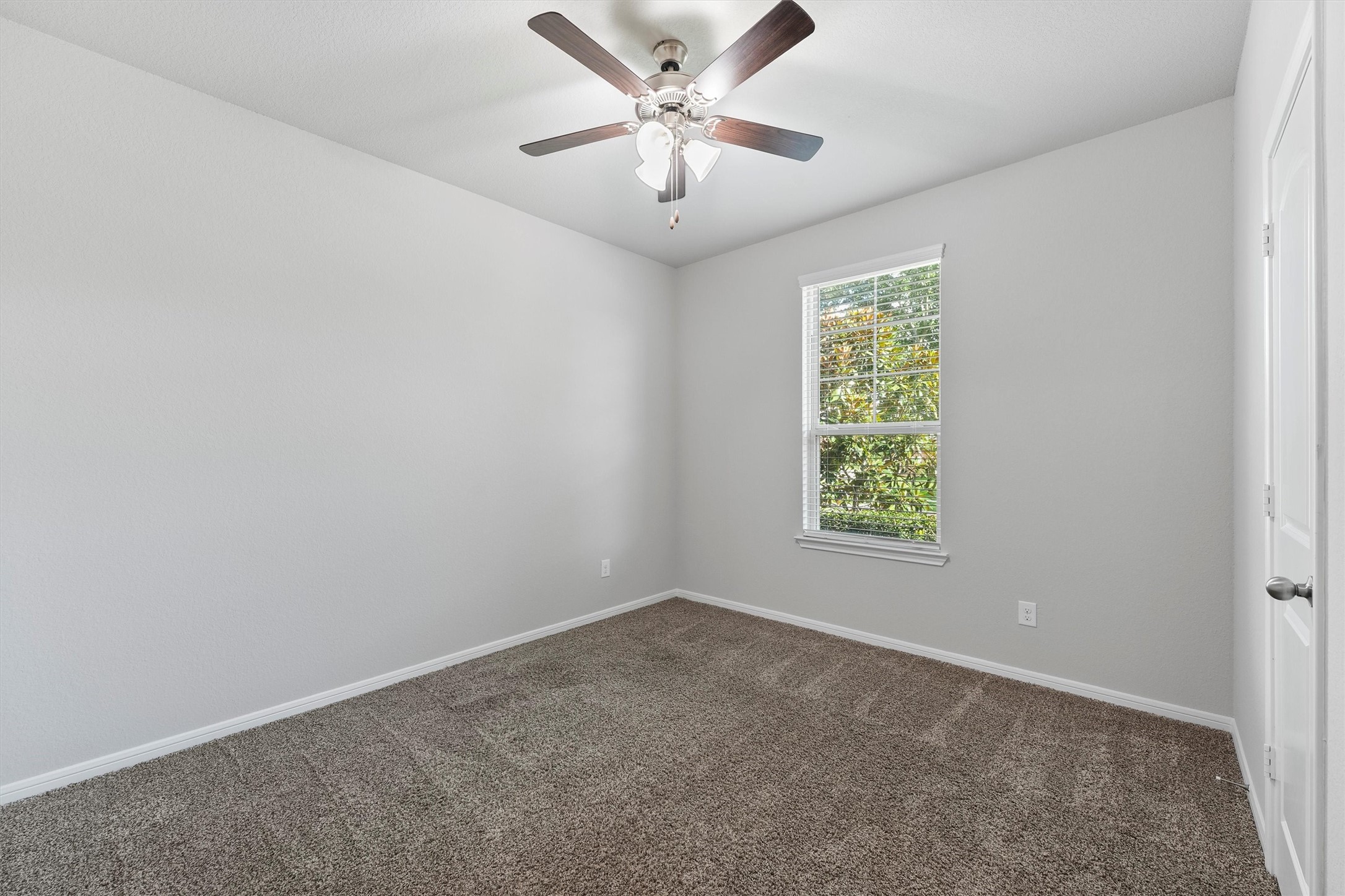 12043 Talmadge Reach Drive Humble, TX 77346 - Photo 5 of 33 an empty room with windows and ceiling fan