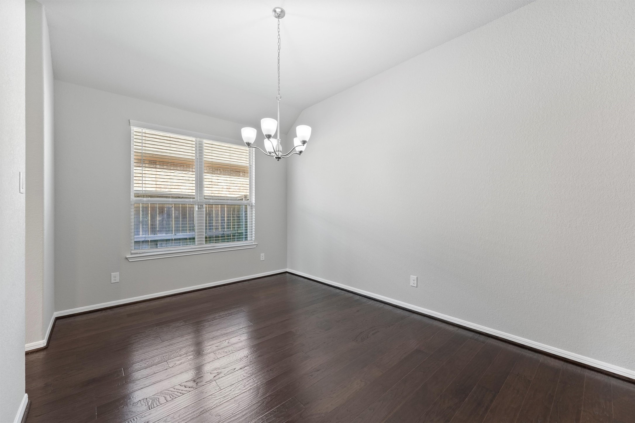 12043 Talmadge Reach Drive Humble, TX 77346 - Photo 7 of 33 a view of an empty room with wooden floor and a window