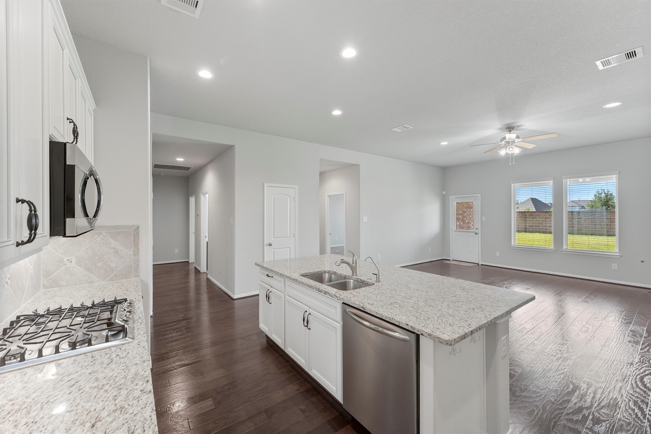 12043 Talmadge Reach Drive Humble, TX 77346 - Photo 10 of 33 a kitchen with stainless steel appliances granite countertop a sink and a stove with wooden floor
