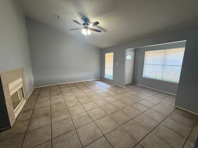 an empty room with windows and fan