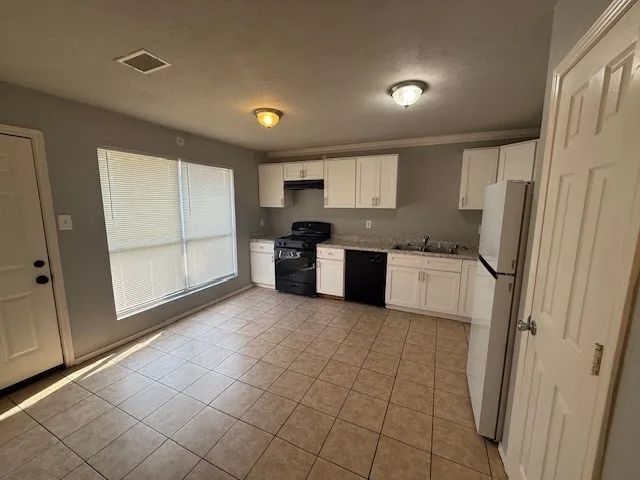 a large kitchen with a stove a refrigerator and a sink