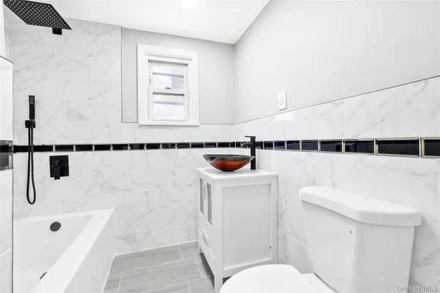 a bathroom with a toilet a sink and mirror