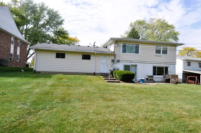 a view of a house with a backyard and a tree