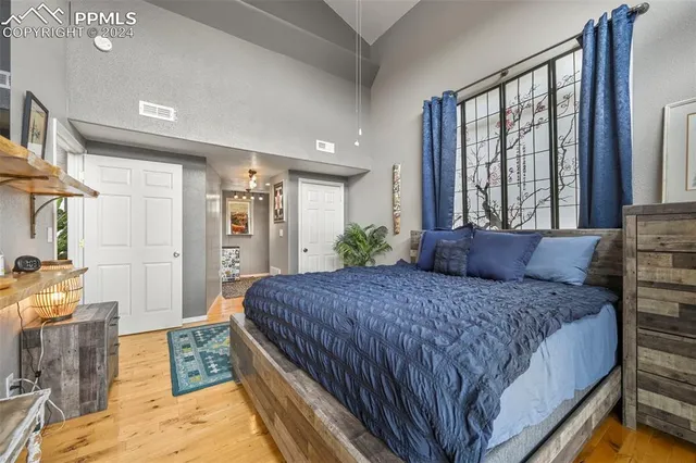 a bedroom with a bed and large windows