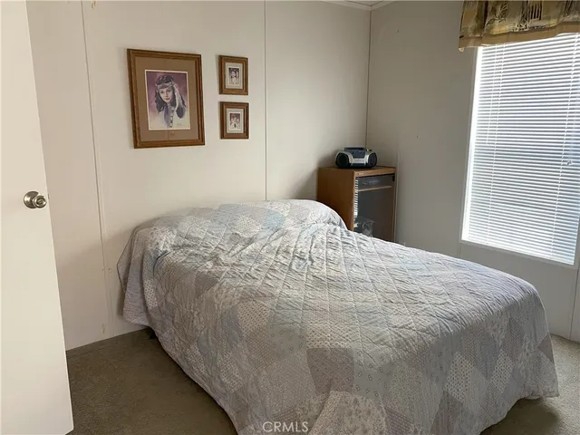 a bed sitting in a bedroom next to a window