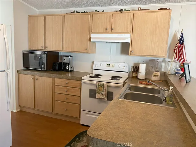 a kitchen with stainless steel appliances a stove a sink and white cabinets