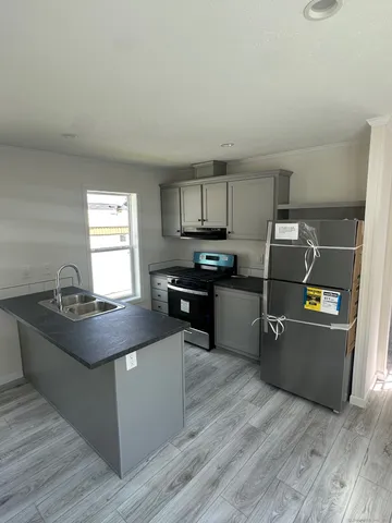 a kitchen with granite countertop a stove top oven and cabinets