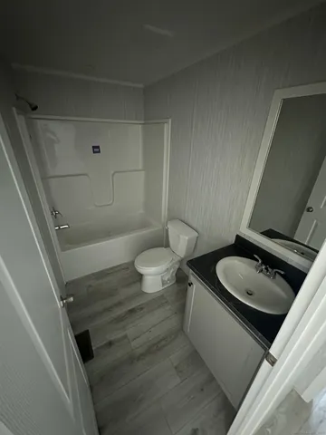 a bathroom with a granite countertop toilet and a sink