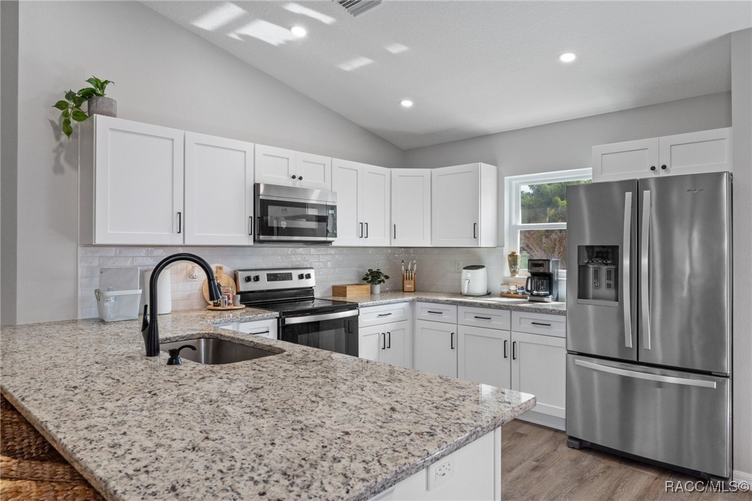 4865 South Tromp Loop Homosassa, FL 34448 - Photo 8 of 30 a kitchen with granite countertop a refrigerator and a stove top oven
