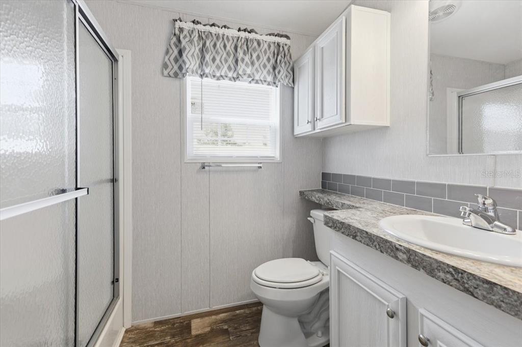 1800 Englewood Road, Unit 166 Englewood, FL 34223 - Photo 17 of 34 a bathroom with a granite countertop sink a toilet and with mirror