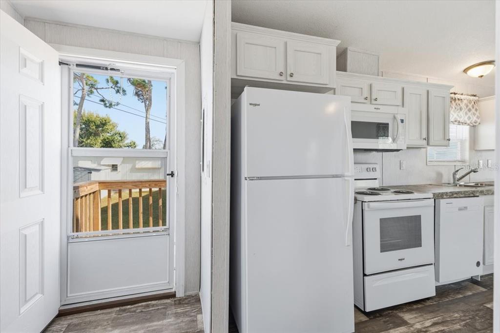 1800 Englewood Road, Unit 166 Englewood, FL 34223 - Photo 5 of 34 a white refrigerator freezer and a stove sitting inside of a kitchen
