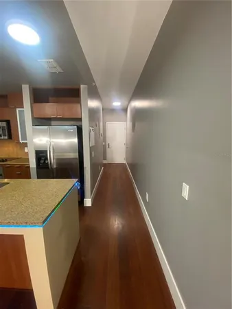 a view of a hallway with stainless steel appliances