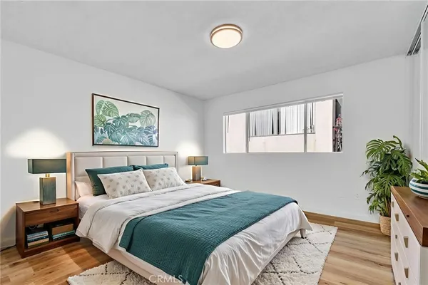 a bedroom with a large bed and a potted plant