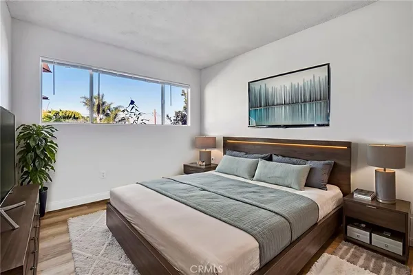a bedroom with a large bed and a potted plant