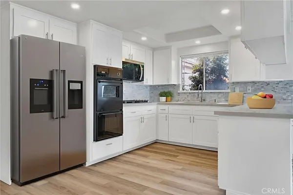 a kitchen with stainless steel appliances a refrigerator sink and microwave