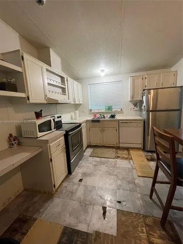 a kitchen with granite countertop a sink stove and refrigerator